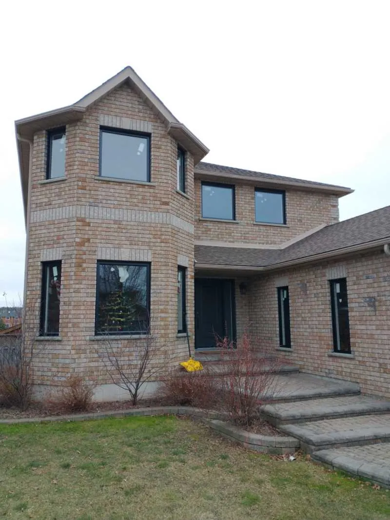 Two-storey brick home with new black-framed windows, installed by Panorama Windows & Doors Two-storey brick home with new black-framed windows