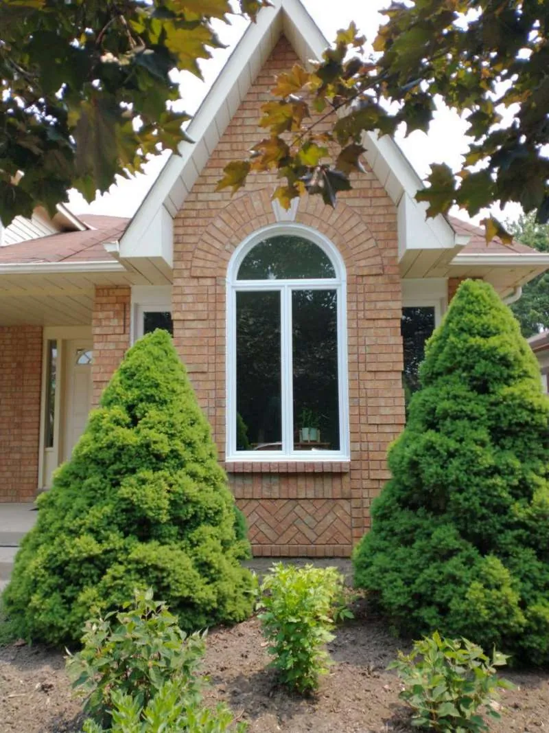 Arched Window Replacement: before Brick bungalow in Barrie with an old white arched window, before replacement