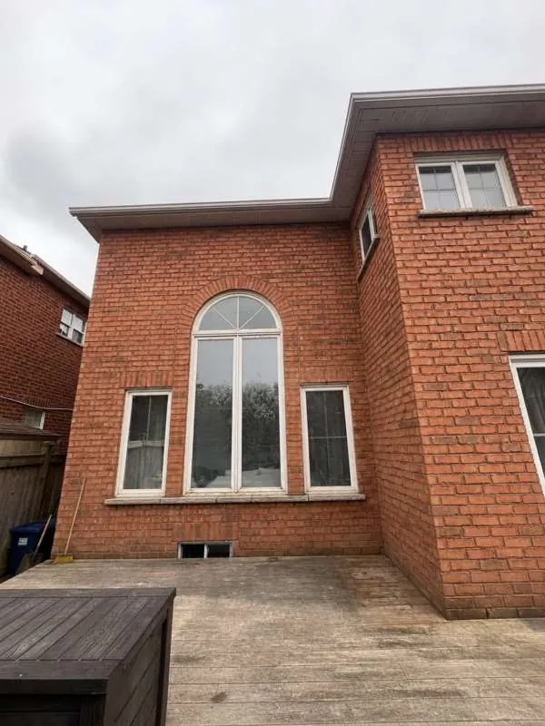 Modern Black Windows Upgrade: before Brick home in Innisfil with white arched and rectangular windows, before replacement