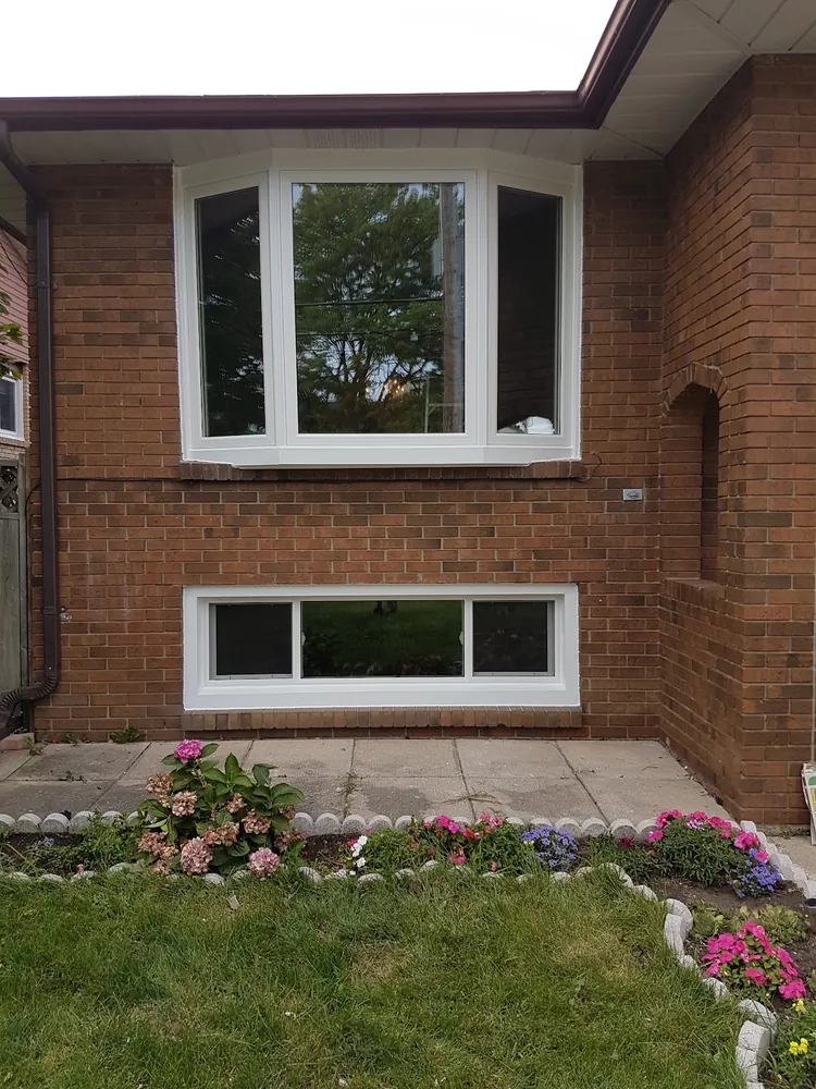 Bow window with a basement slider on red brick in Hamilton, installed by Panorama Windows & Doors Bow window with a basement slider on red brick in Hamilton